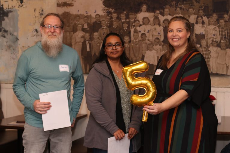 Staff holding 5 years of service balloons.