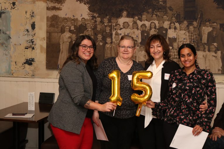 Staff holding 15 years of service balloons.