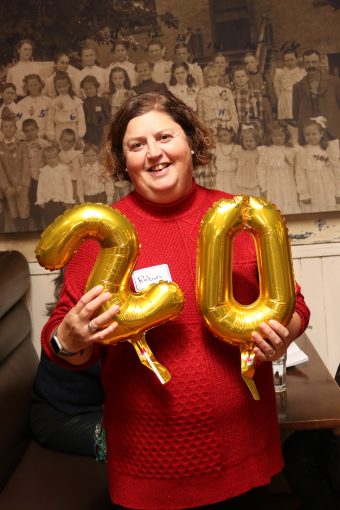 Staff holding 20 years of service balloons.