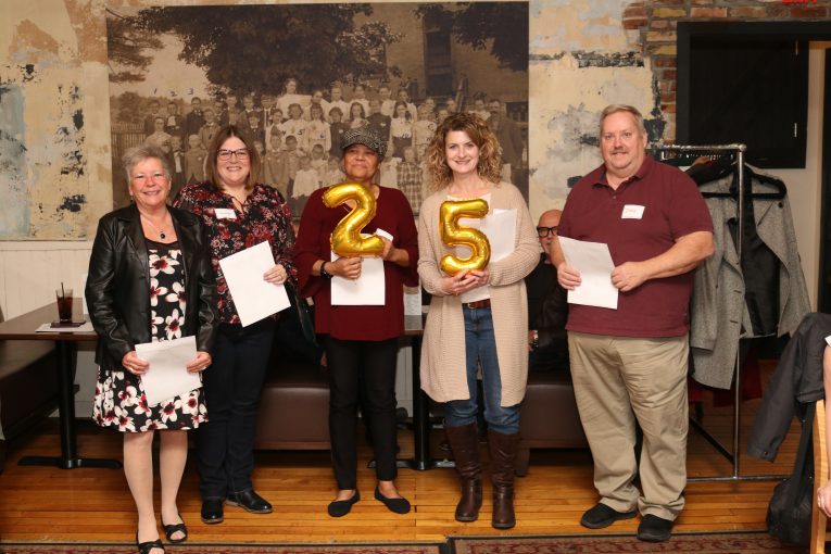 Staff holding 25 years of service balloons.