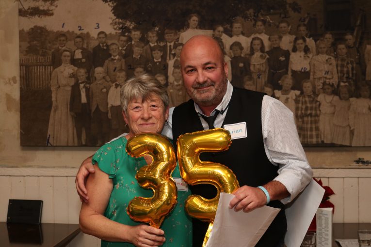 Staff holding 35 years of service balloons.