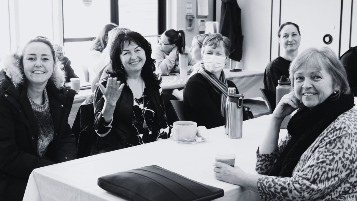 5 people from Early Learning smiling during a team meeting in the Bullas Hall.