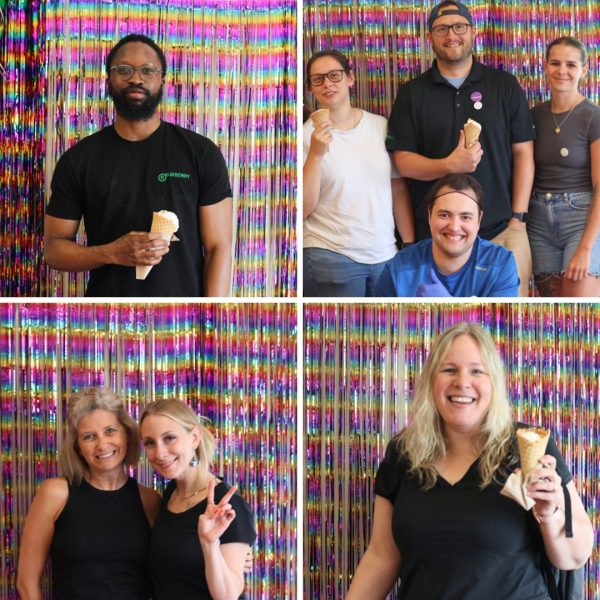 Pictured are staff members smiling together in front of a colourful rainbow tinsel background smiling and holding ice cream cones!