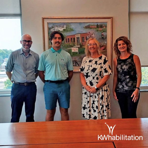 MP Mike Morrice standing next to Colby Switzer (CSJ Student), with CEO of KW Habilitation Ann Bilodeau, and Stacey Mitchell, Manager of Community & Employment Supports at KW Habilitation in the Board room at KW Habilitation's Main office.