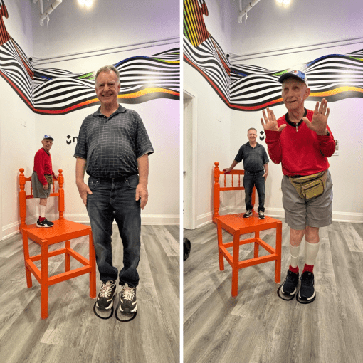 Tony and Jim at the chair illusion exhibit at the Mi Museum. The chair is orange. (Left) Jim stands beside the chair and he looks like a giant! While Tony looks tiny on the orange chair beside him making an illusion. (Right) Tony stands beside the chair and he looks like a giant! While Jim looks tiny on the orange chair beside him making an illusion.