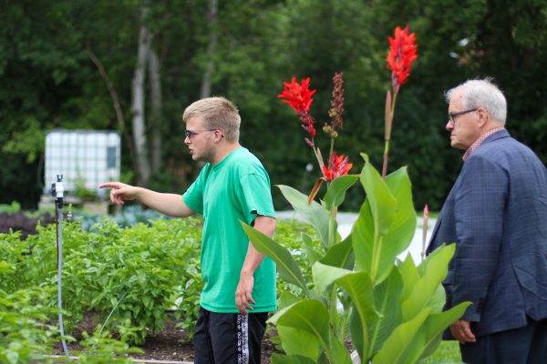 CSJ staff member Cooper Fraser Moore shows the Minister of Agriculture the Honourable Lawrence Mac Aulay our irrigation system.