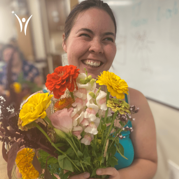 Madeline holding her freshly made bouquet made with Our Farm flowers!