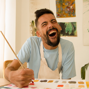 A person painting and smiling