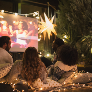 People watching a movie on a screen outdoors