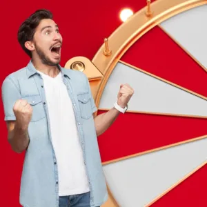 a white man super excited with his fists closed together. in the background of the photograph is a roulette type wheel.