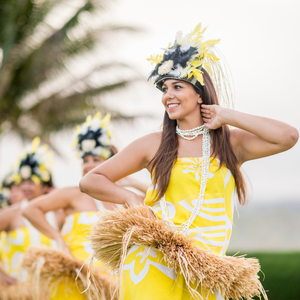 Dancers wearing traditional Hawaiian grass hula skirts.