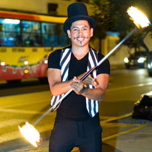 A person in a costume twirling a flaming baton.