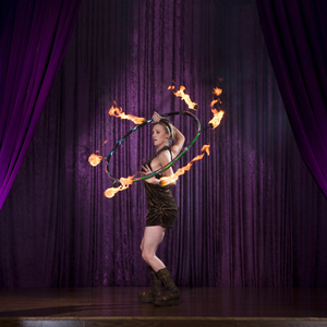 A person performing with a flaming hoop