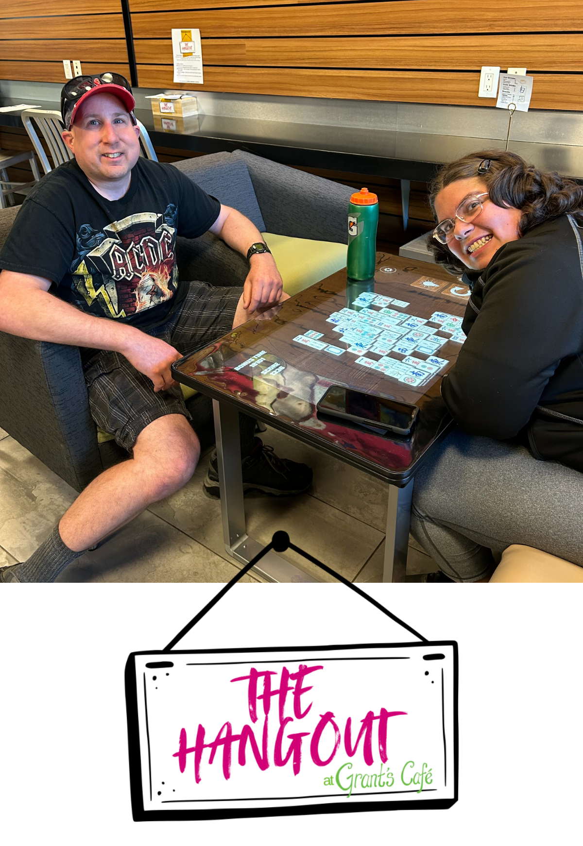 Two people smiling as they play a game together on a large gaming tablet table