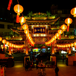 A pagoda with traditional Chinese lanterns light up a night time marketplace.