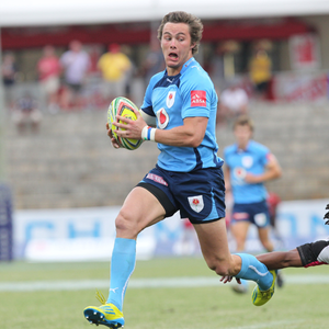 A person carrying a rugby ball while running away from another player.