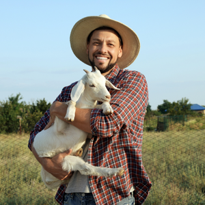 A person holding a baby goat