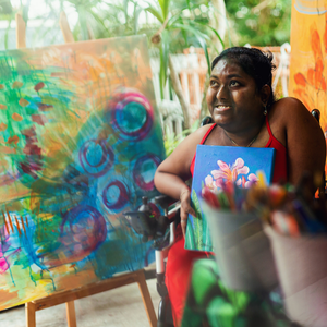 A person showing off the colourful artwork that they've painted.