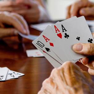 A person's hand holding 5 cards. We can see they have 3 aces and a 10.
