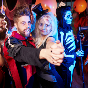 People wearing Halloween costumes and dancing.