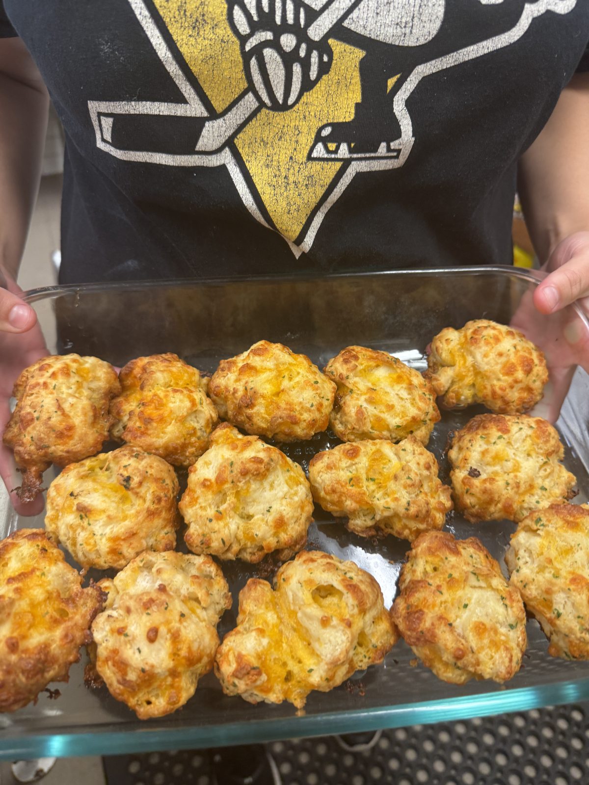 cheddar bay biscuits in a tray held by a baker
