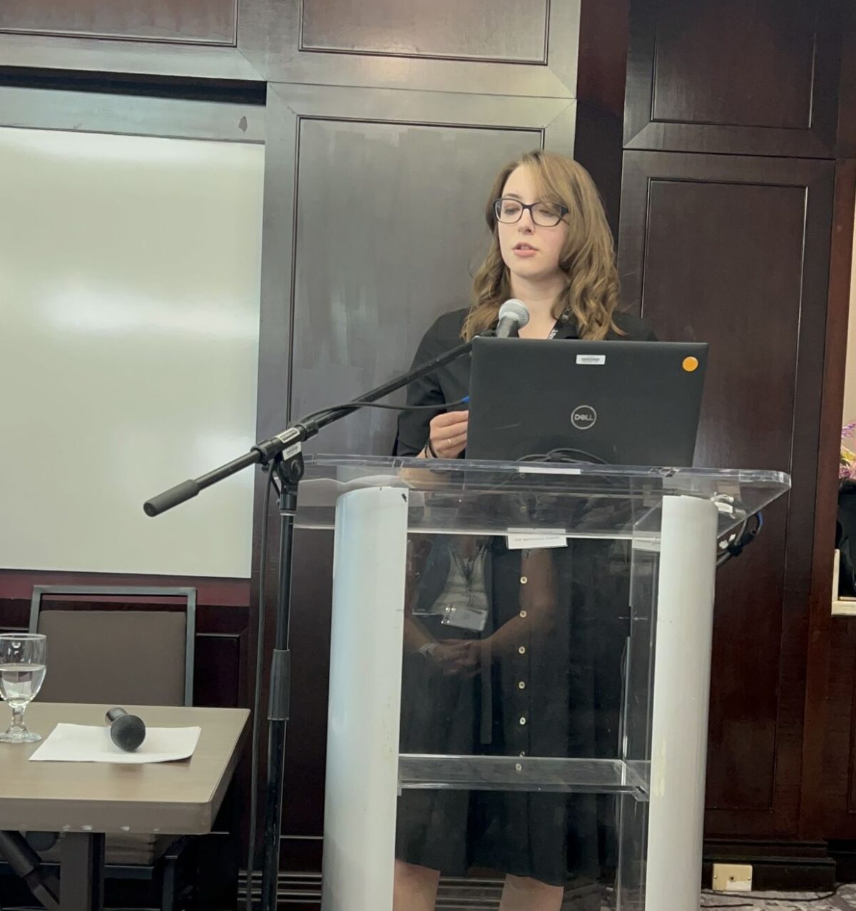 photo of a young woman giving a speech at a podium.