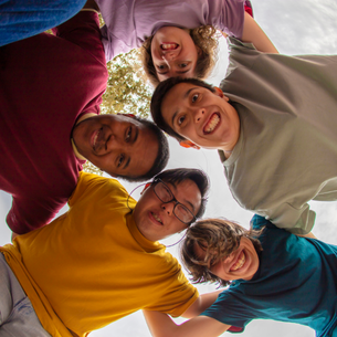 A group of 5 people in a circle looking down into the middle at the camera perspective.