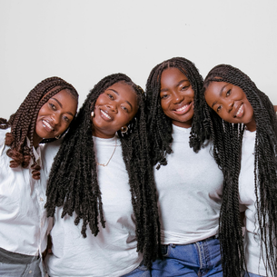 Four people smiling. They all appear to be of African descent.