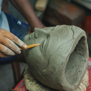 A person using clay to sculpt a face.