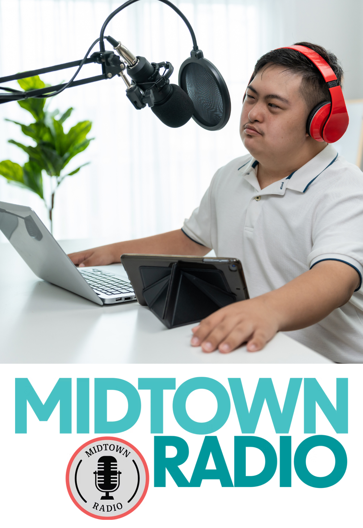 A person wearing headphones. They have a laptop and a tablet in front of them. There is a long metal arm holding a microphone in front of the person.