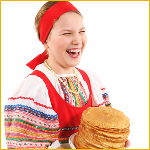 A woman wearing bright colours and holding a stack of pancakes while laughing.