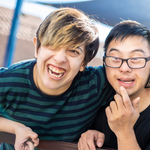 Two people smiling and having fun together. One of the people is wearing a green shirt.
