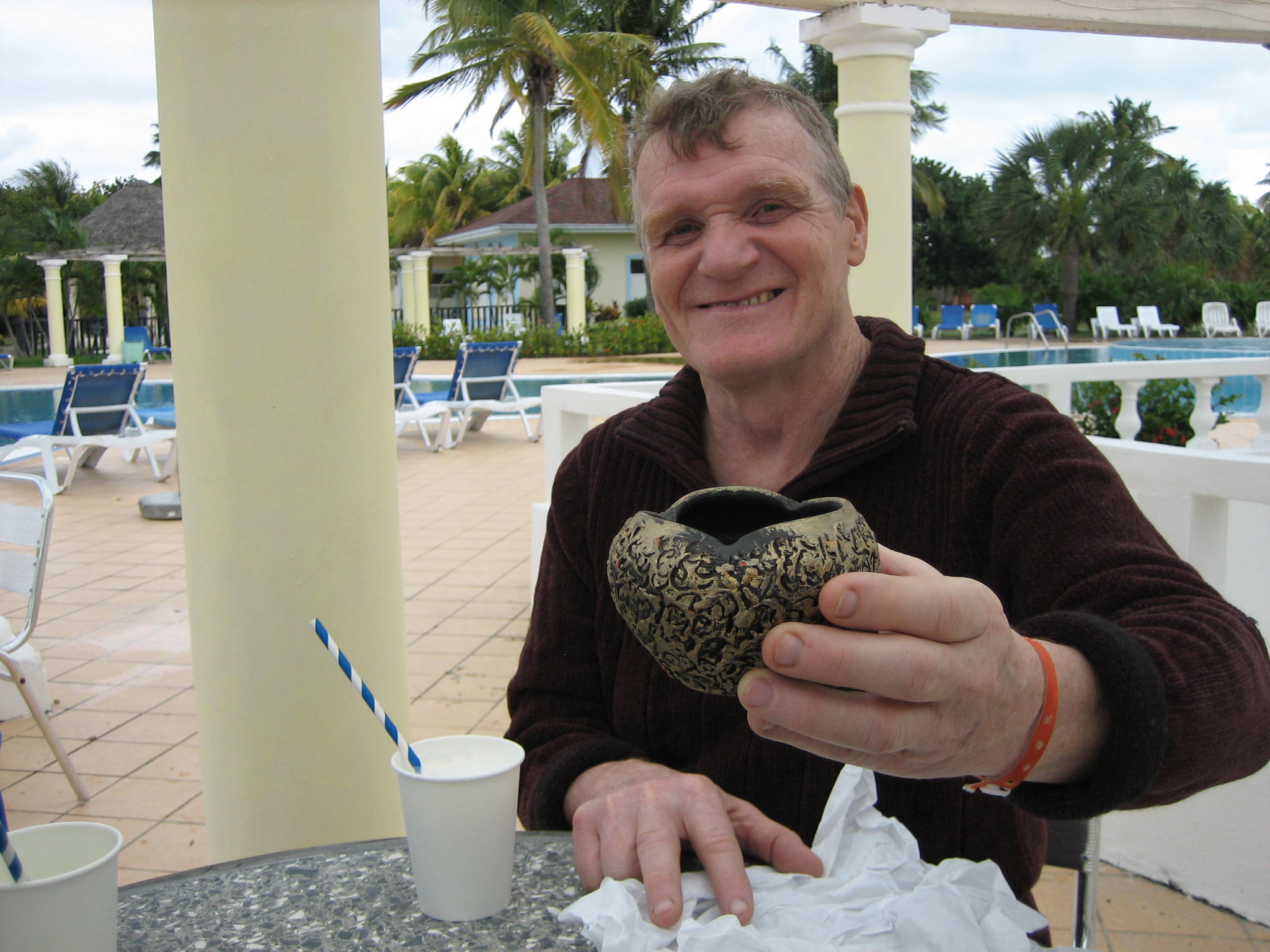 Photo of Robert holding a piece of pottery at a resort in Cuba