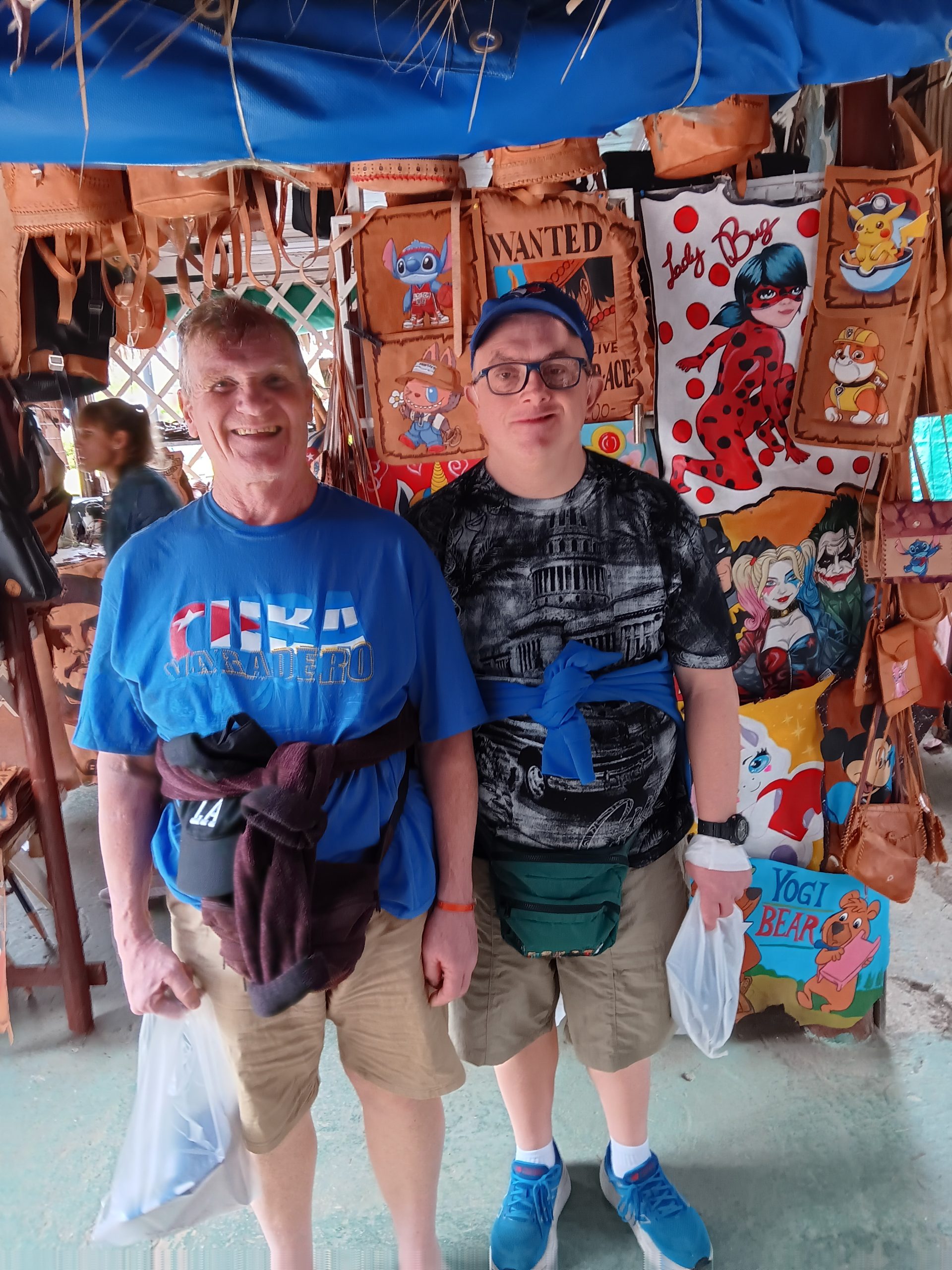 Photo of two adults in Veradero Cuba. They are under a tent in a marketplace