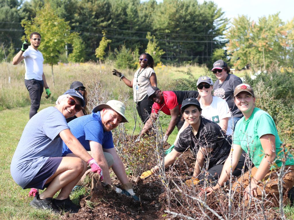 a group of smiling people weeding