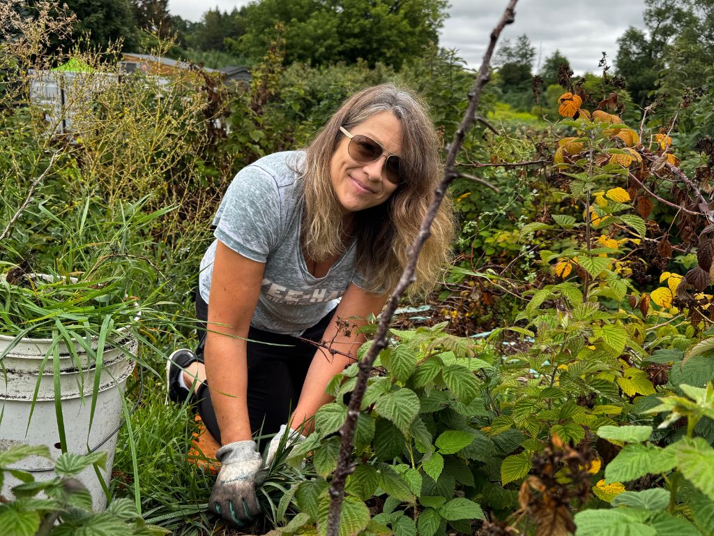 a woman smiling while weeding
