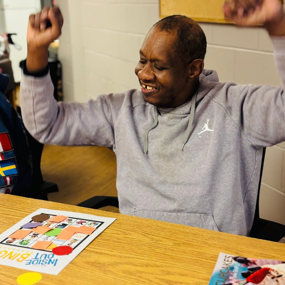 smiling man sitting down celebrating a win at bingo