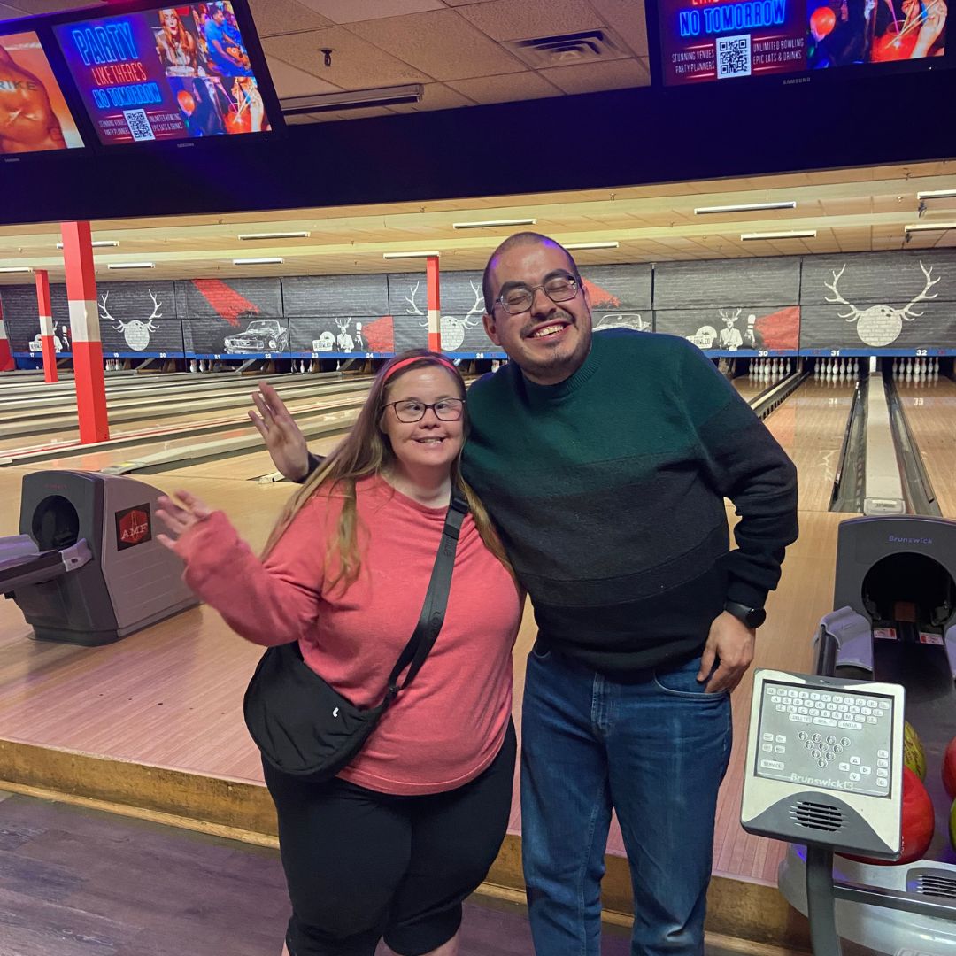 two smiling people at a bowling alley