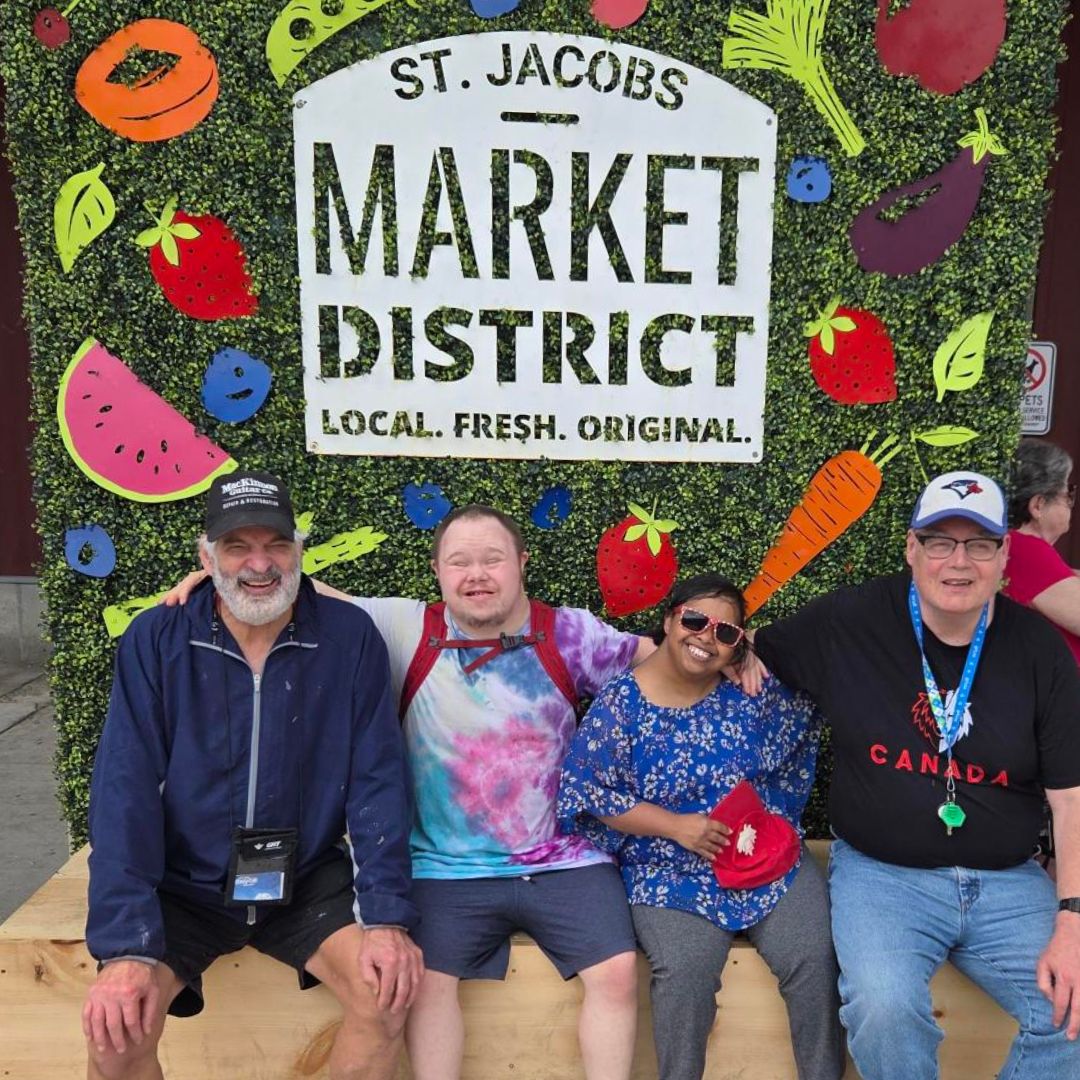 group of people at the st. Jacobs market district sign